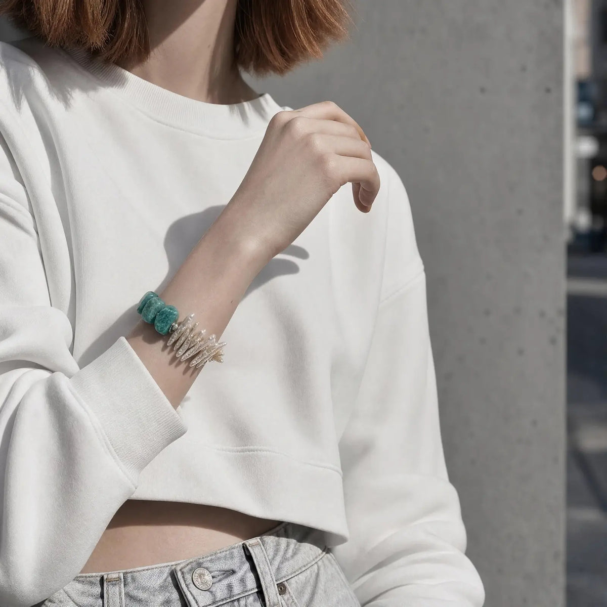 Close wrist view of the Electric Tide Amazonite & Pearl Bracelet with chunky blue-green amazonite and elongated white baroque stick pearls