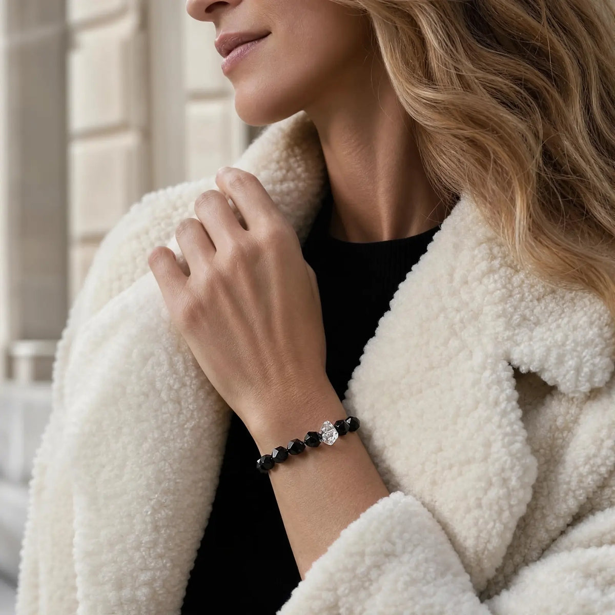 Styled wrist view of the Noir Facet Onyx & Pearl Bracelet with faceted black onyx, translucent included quartz, and pearl accents