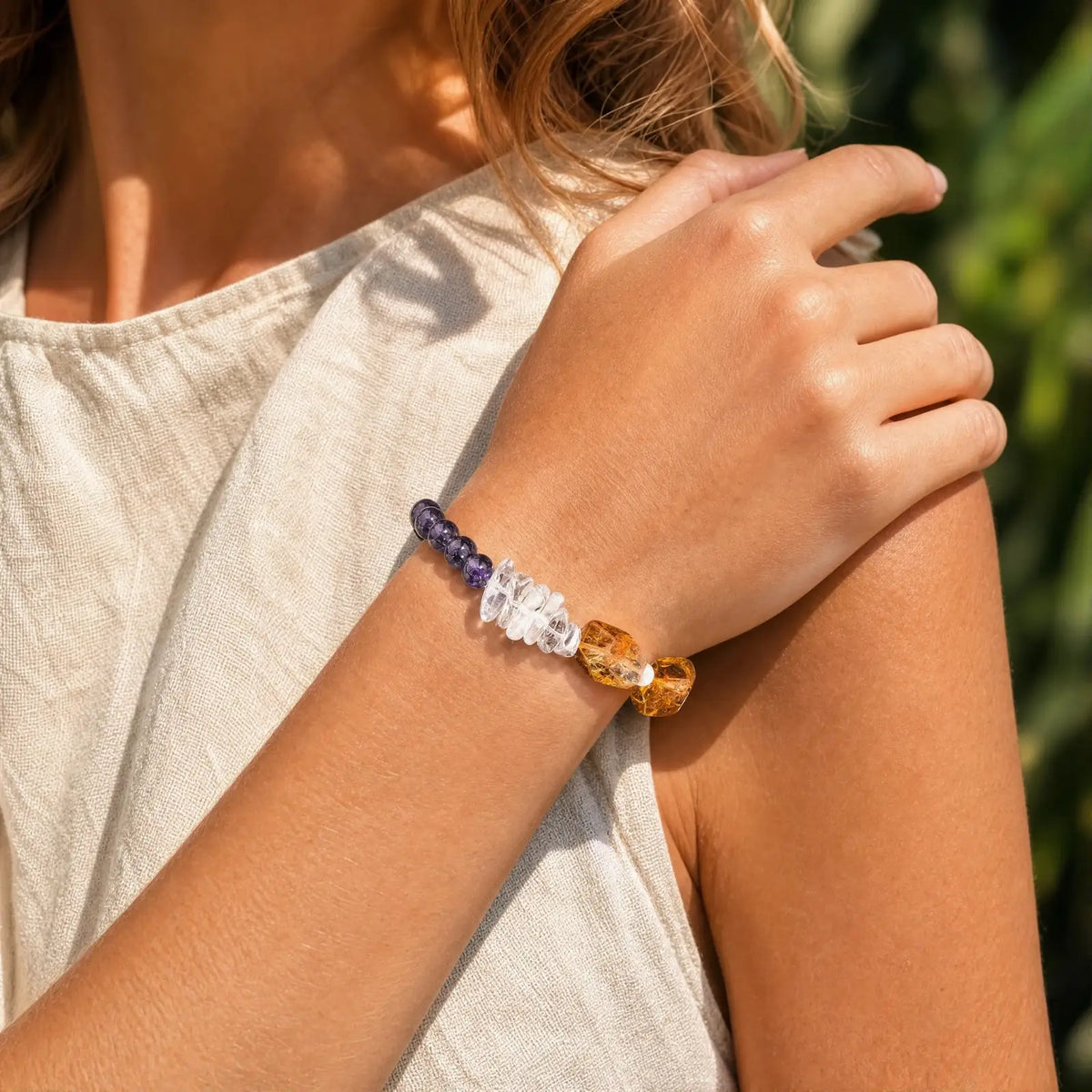 Styled wrist view of the Solar Violet Mixed-Crystal Bracelet with golden freeform stones, clear quartz, and violet amethyst sections