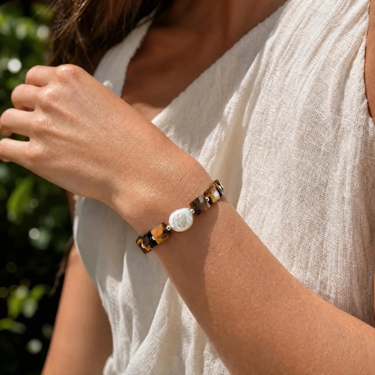 Wrist view of the Golden Block Tiger's Eye & Pearl Bracelet with faceted golden-brown tiger's eye blocks and a central baroque pearl