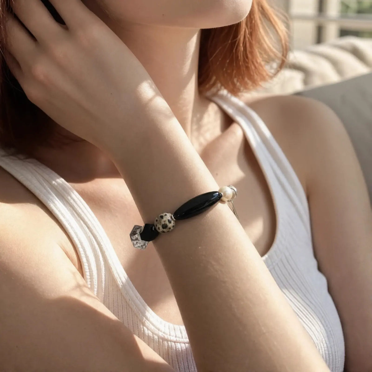 Wrist view of the Speckled Moon Mixed-Stone Bracelet with black, pale, clear, pearl, and speckled natural stone forms
