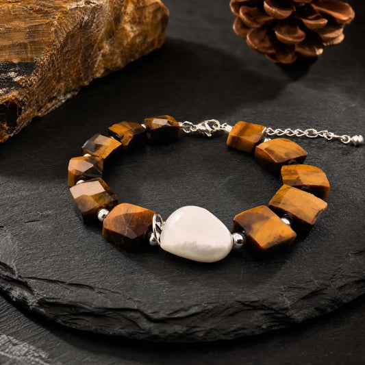 Angled view of the Golden Block Tiger's Eye & Pearl Bracelet showing faceted golden-brown tiger's eye blocks and a central baroque pearl