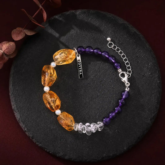 Angled view of the Solar Violet Mixed-Crystal Bracelet showing golden freeform stones, clear quartz, and violet amethyst sections