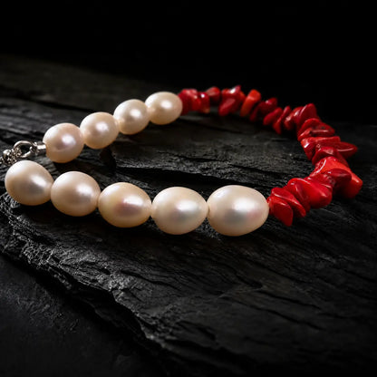 Close product view of the Crimson Divide Pearl Bracelet showing an asymmetric split of red stone chips and freshwater pearls