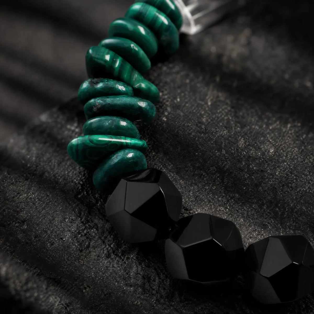 Close-up of green malachite, black onyx, clear quartz, pearl, and spotted stone sections on the Verdant Circuit Malachite & Onyx Bracelet