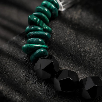 Close-up of green malachite, black onyx, clear quartz, pearl, and spotted stone sections on the Verdant Circuit Malachite & Onyx Bracelet