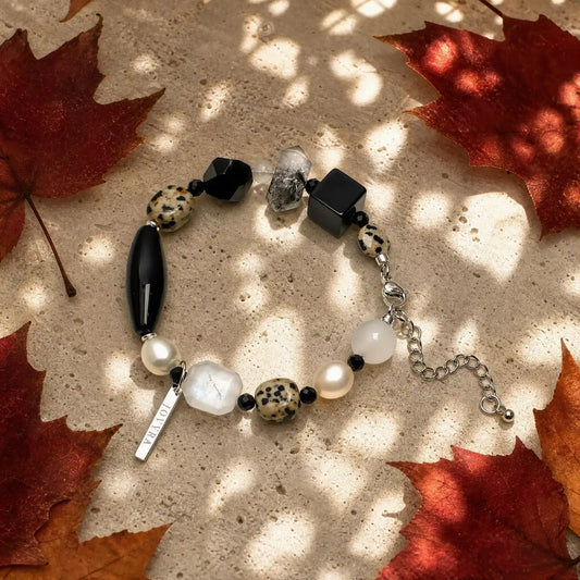 Flat-lay view of the Speckled Moon Mixed-Stone Bracelet showing black, pale, clear, pearl, and speckled natural stone forms