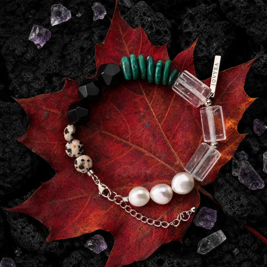 Flat-lay view of the Verdant Circuit Malachite & Onyx Bracelet showing green malachite, black onyx, clear quartz, pearl, and spotted stone sections