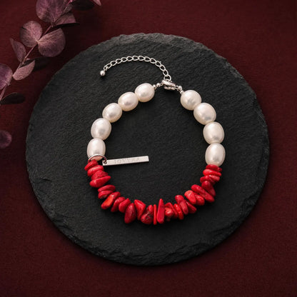 Full view of the Crimson Divide Pearl Bracelet showing an asymmetric split of red stone chips and freshwater pearls