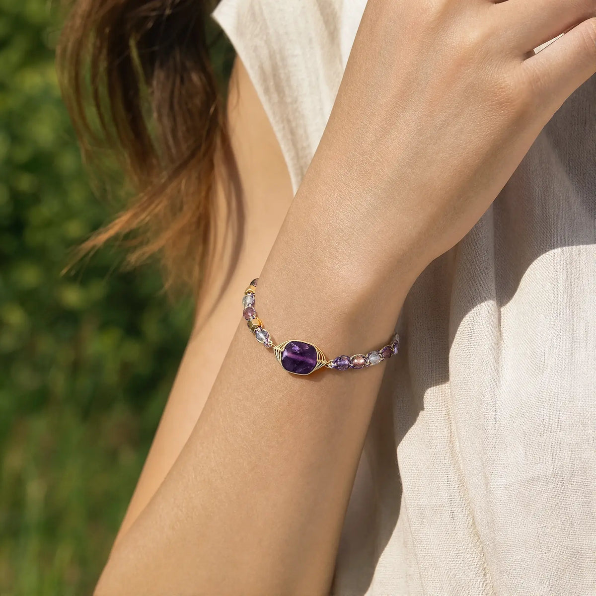 Violet fluorite braided bracelet worn with a light summer dress
