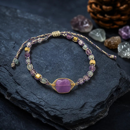 Violet fluorite braided bracelet arranged on a dark mineral surface