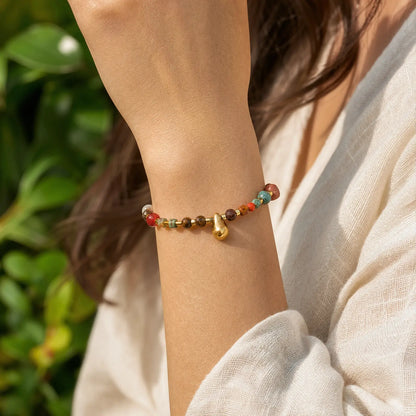 Tiger eye drop bracelet worn with a relaxed white sleeve