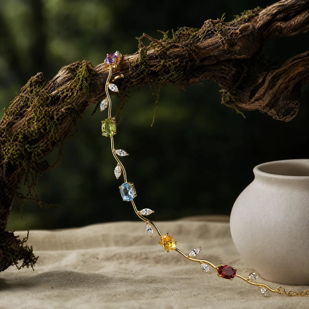 Multicolored vine bracelet draped over a mossy branch beside a ceramic vessel