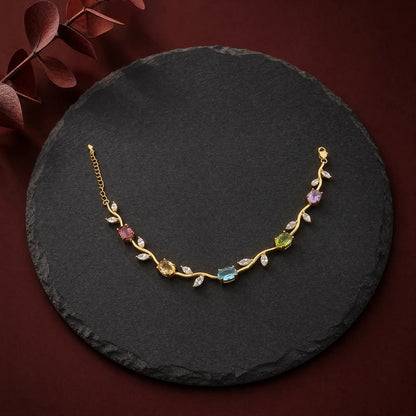 Natural multi-stone vine bracelet with gold-tone setting on dark slate