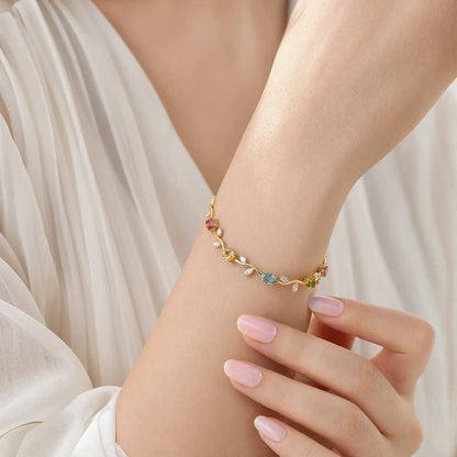 Multicolored vine bracelet worn on a woman's wrist against white fabric