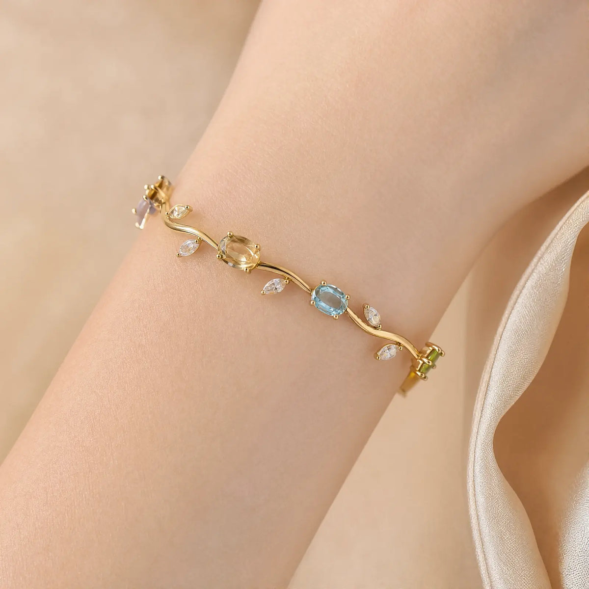 Close wrist view of the colorful stone and leaf pattern on a vine bracelet
