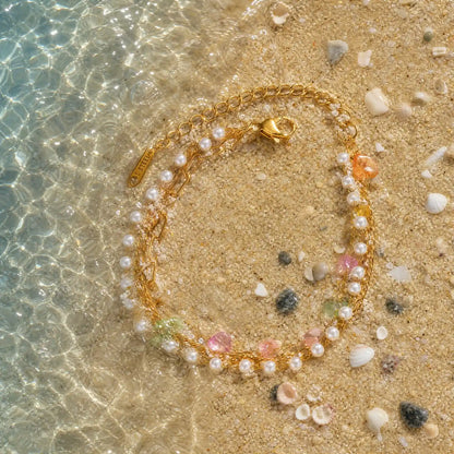 Pearlescent stainless steel strand arranged in shallow water on sand