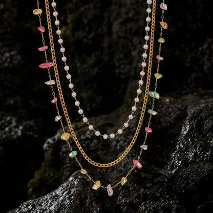 Pearlescent layered necklaces displayed on dark seaside rock