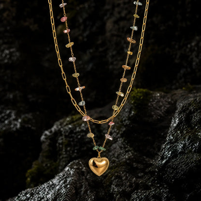 Heart pendant layered necklaces displayed on dark seaside rock
