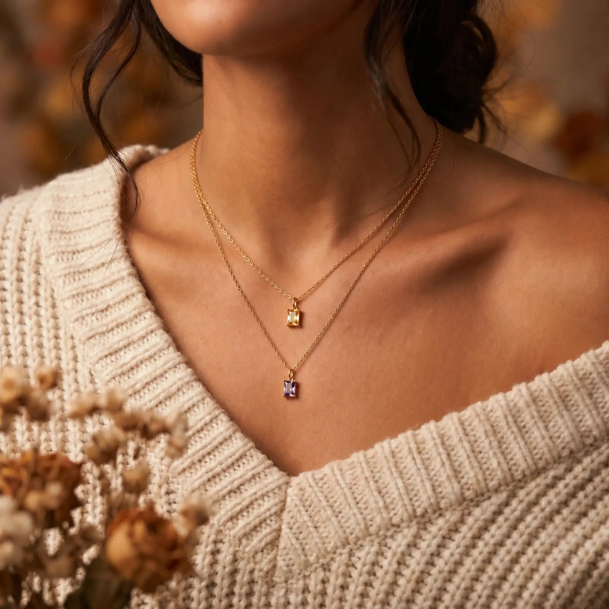 Three rectangular birthstone pendant necklaces worn with warm knitwear