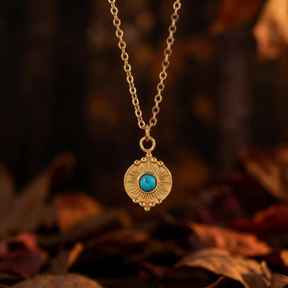 Round natural turquoise pendant necklace styled on autumn leaves