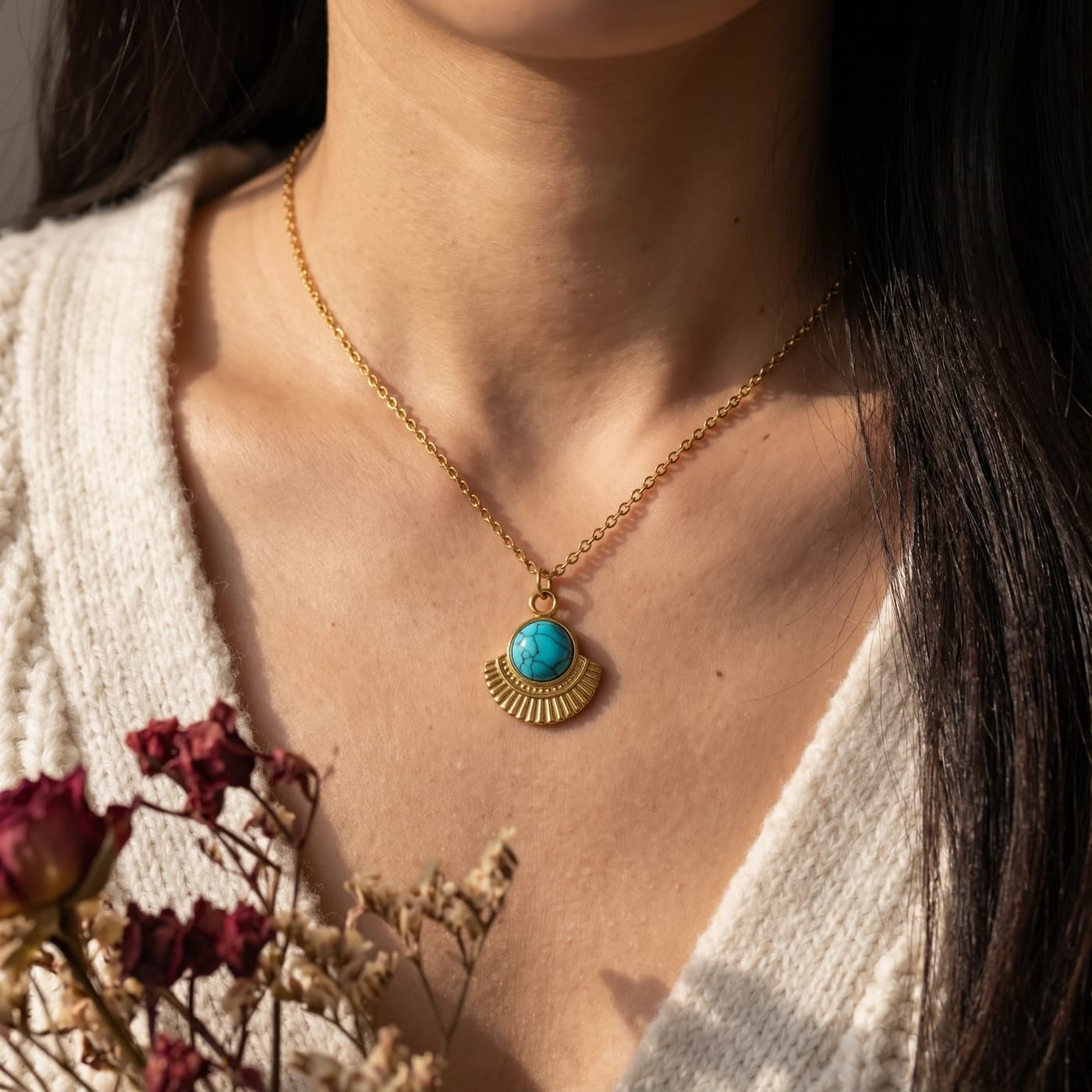 Round natural turquoise pendant necklace worn with a cream cardigan and flowers