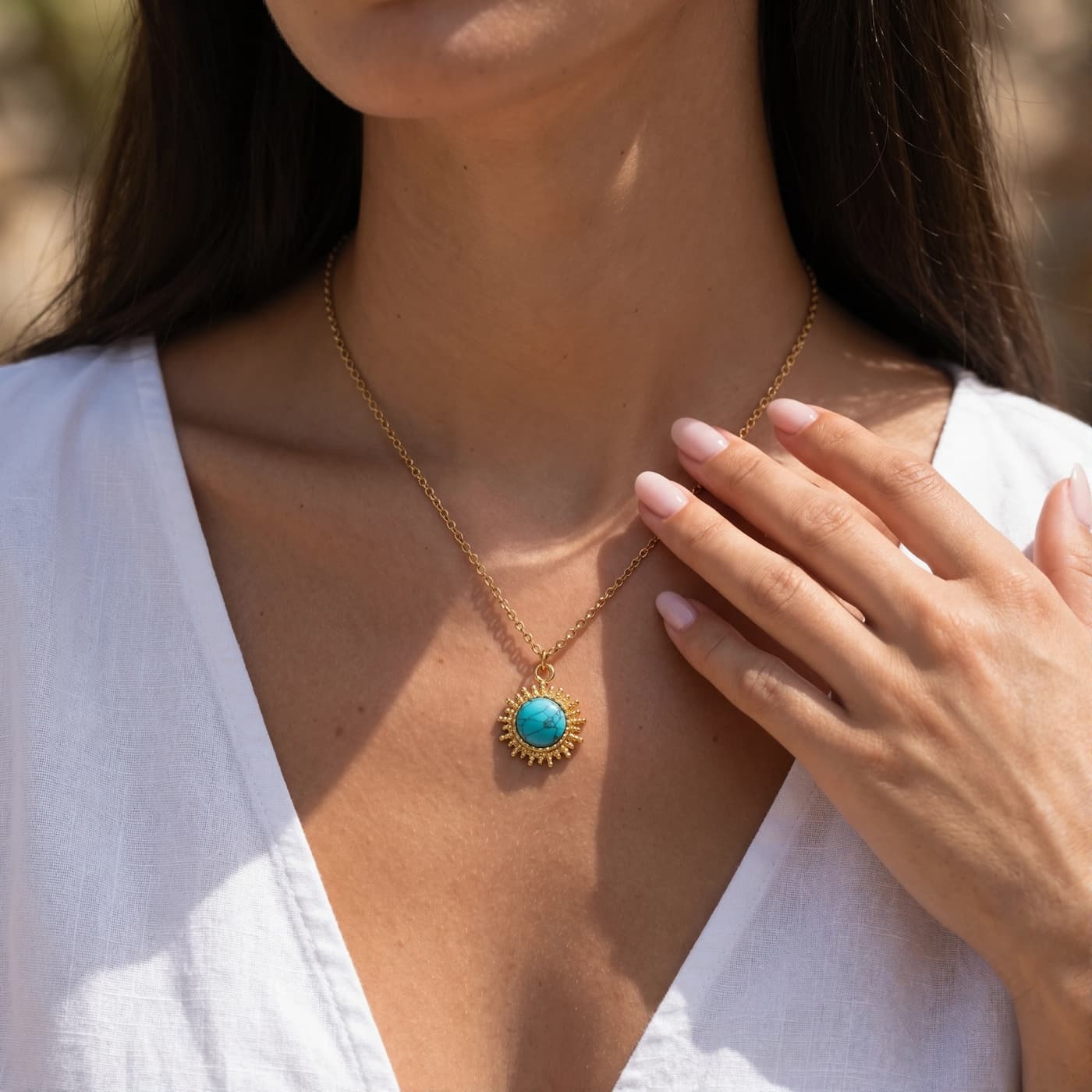 Round natural turquoise pendant necklace worn with a white blouse