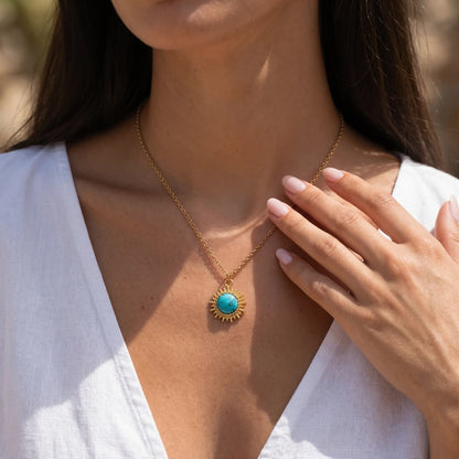 Round natural turquoise pendant necklace worn with a white blouse