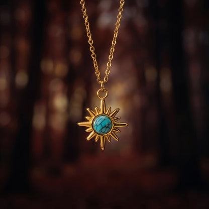 Gold-tone starburst natural turquoise pendant necklace in a warm forest setting