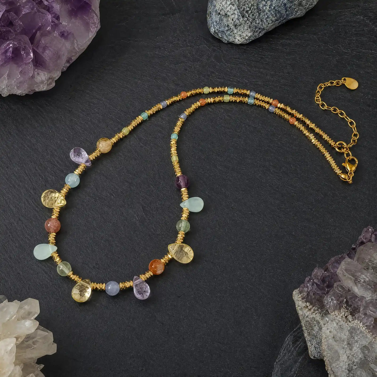 Multicolor natural stone necklace arranged beside raw crystal accents