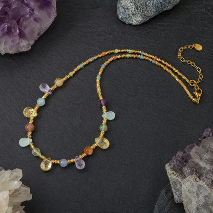 Multicolor natural stone necklace arranged beside raw crystal accents
