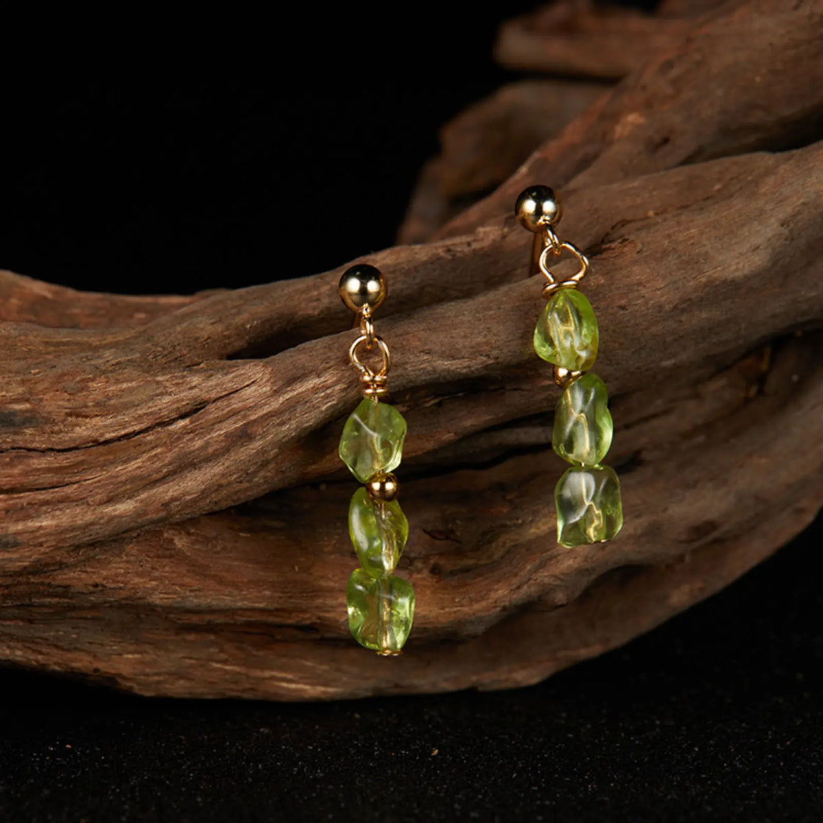 Gold-tone drop earrings with irregular green peridot beads