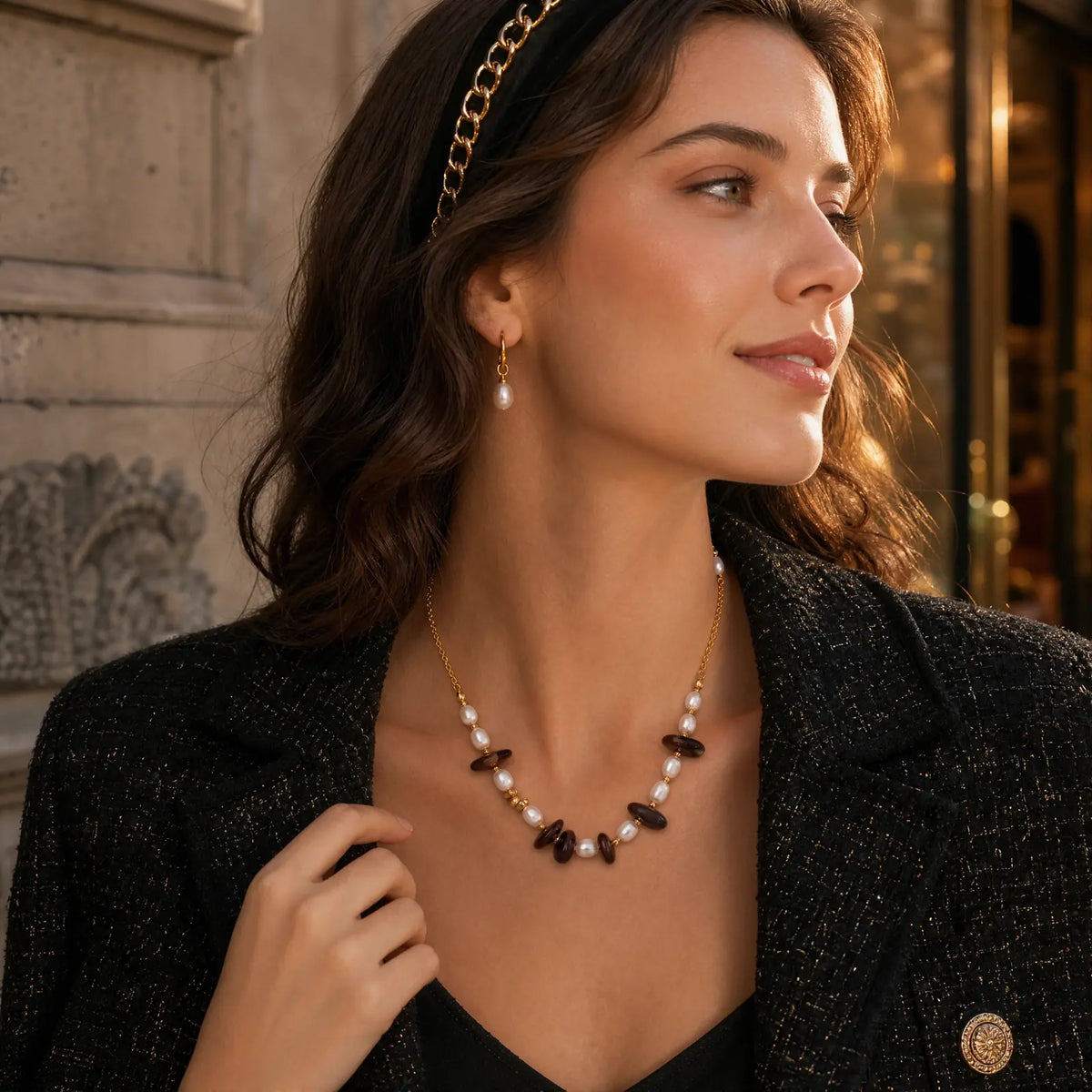 Woman wearing a smoky quartz and pearl necklace with a dark blazer