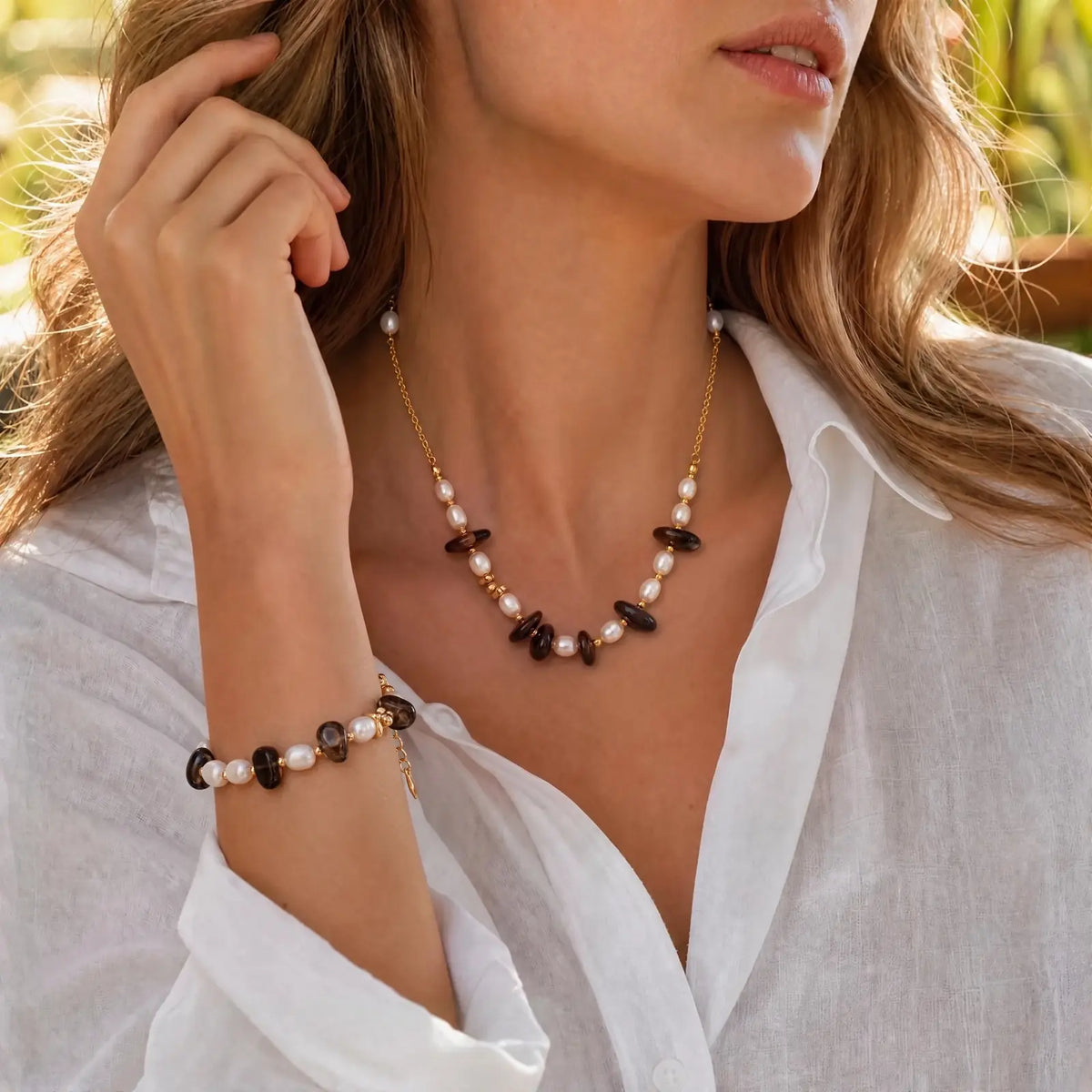 Woman wearing the smoky quartz pearl necklace and matching bracelet