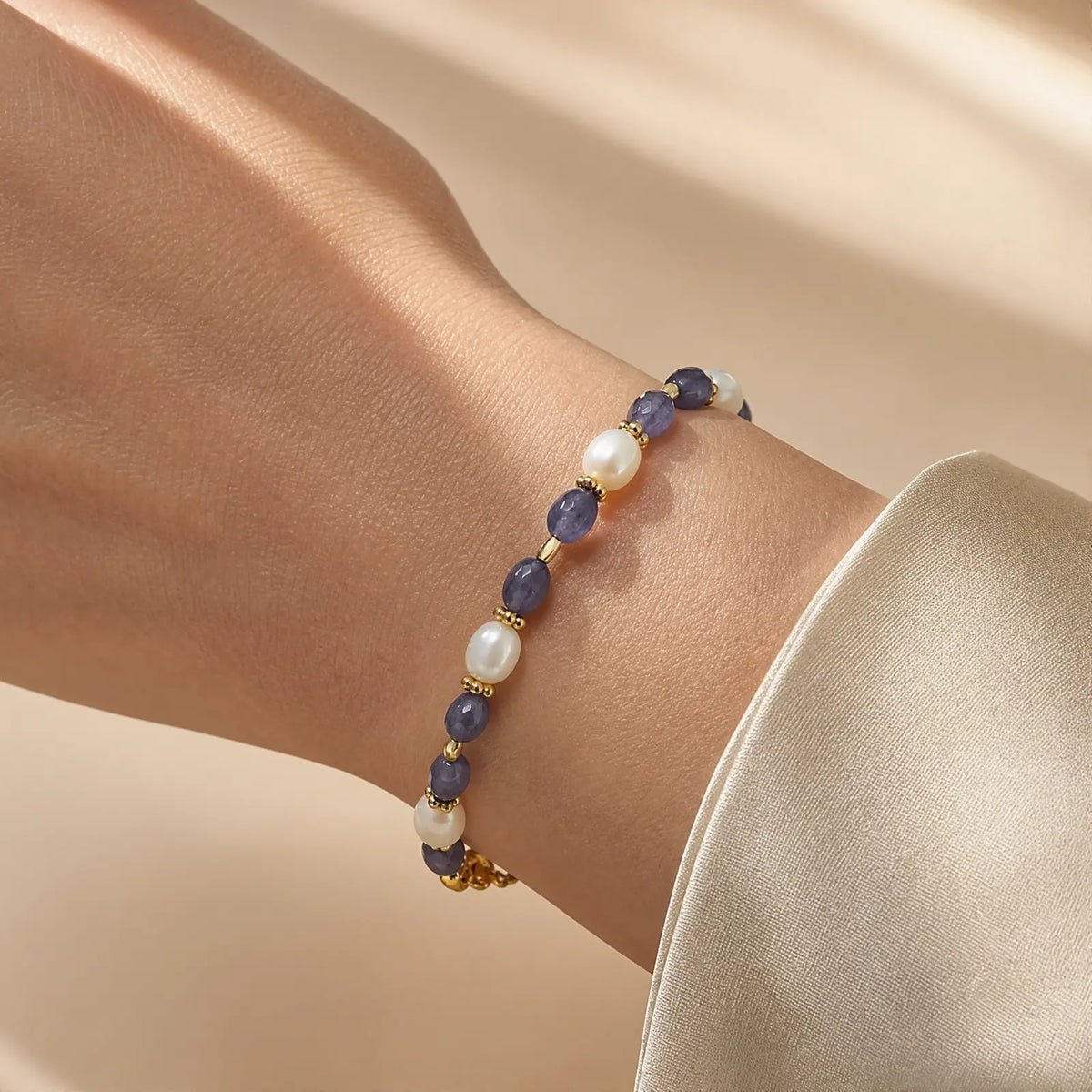 Close wrist view of a tanzanite and pearl bracelet