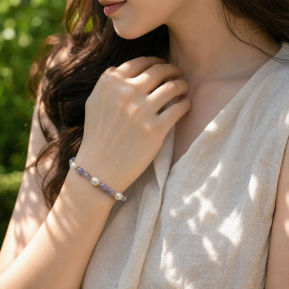 Woman wearing a blue-violet tanzanite and pearl bracelet