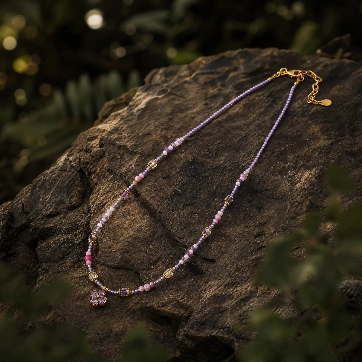 Lilac Clover beaded necklace on a dark mineral surface