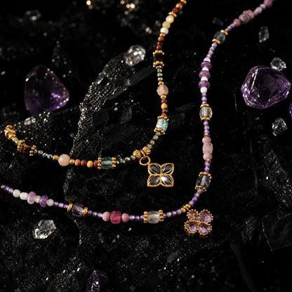 Lilac and tiger eye clover necklaces displayed together in natural light