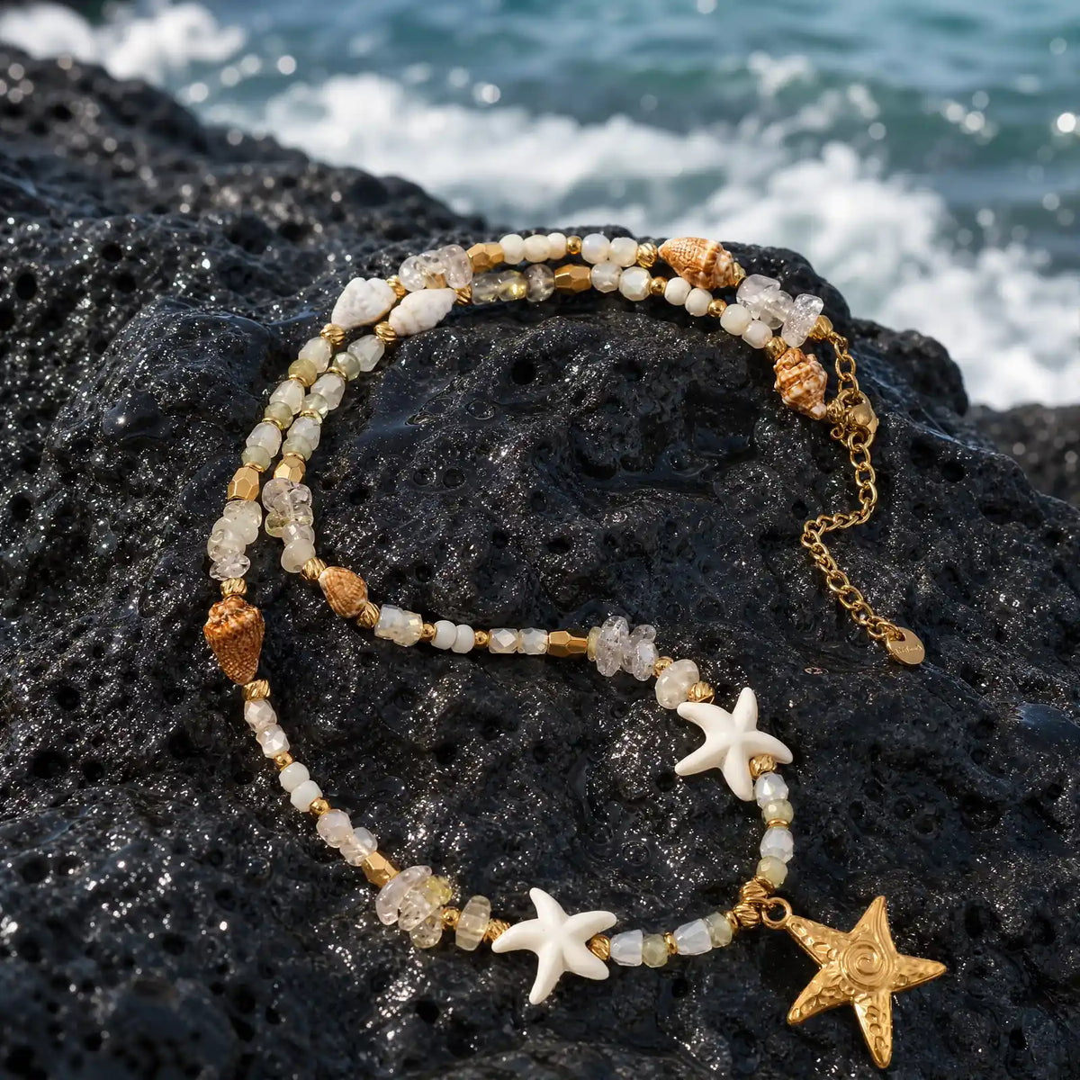 Starfish necklace and coordinating coastal pieces arranged on dark seaside rock