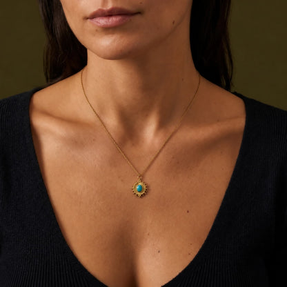 Oval turquoise pendant necklace worn with a black neckline.