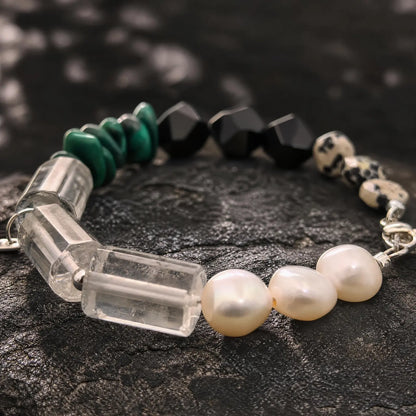 Macro detail of green malachite, black onyx, clear quartz, pearl, and spotted stone sections on the Verdant Circuit Malachite & Onyx Bracelet