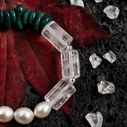 Styled display of the Verdant Circuit Malachite & Onyx Bracelet showing green malachite, black onyx, clear quartz, pearl, and spotted stone sections